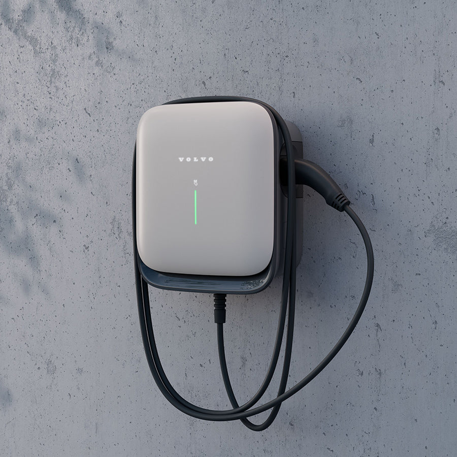 Die Volvo Wallbox mit aufgerolltem Kabel an einer Betonwand