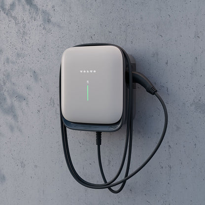 Die Volvo Wallbox mit aufgerolltem Kabel an einer Betonwand